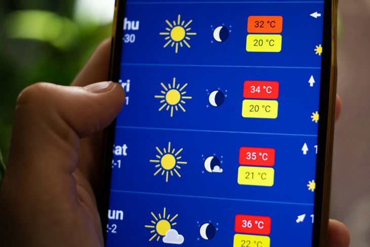 person checking weather app summer heat