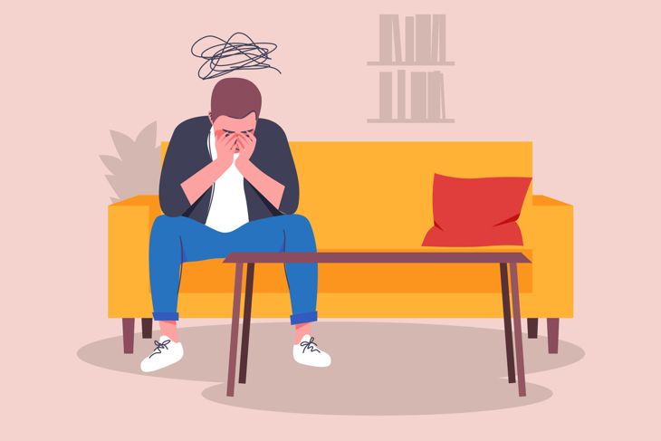 A lonely man sitting on a couch in the office of a psychoanalyst
