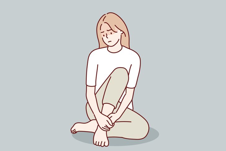 Sad and lonely teenager girl sitting in lotus position on the floor and lowered her head down