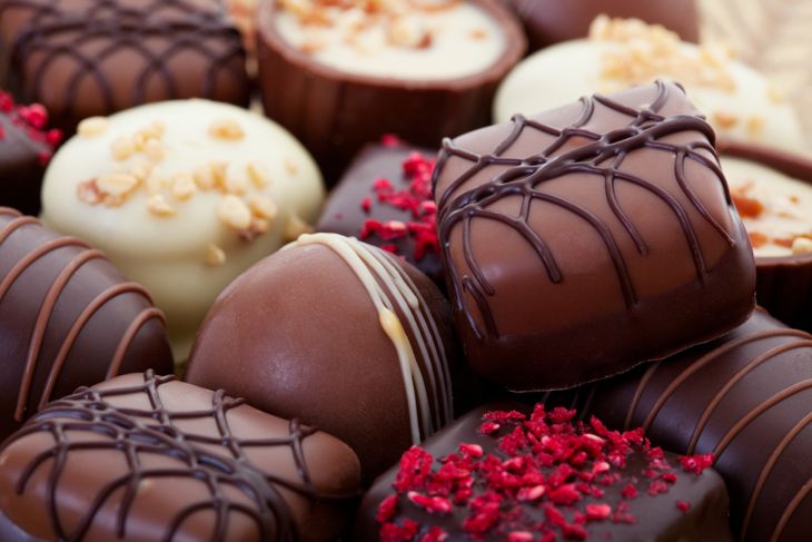 An assortment of fine chocolates in white, dark, and milk chocolate.