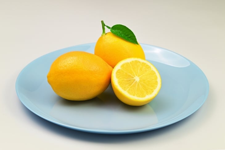 Three lemons are on a blue plate.