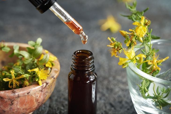 Dropping red St. John's wort oil into a brown glass bottle