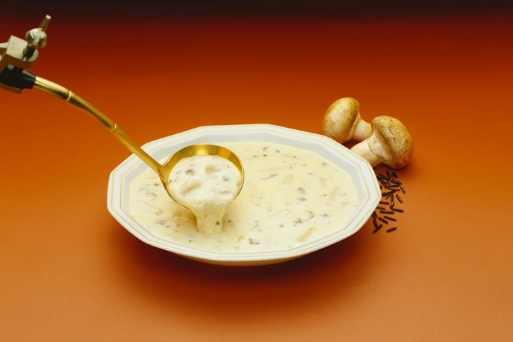 a bowl of cream of mushroom soup with a spoon sticking out of it
