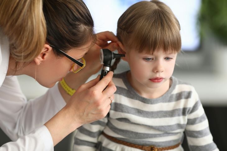 Doctor uses an otoscope on a child patient