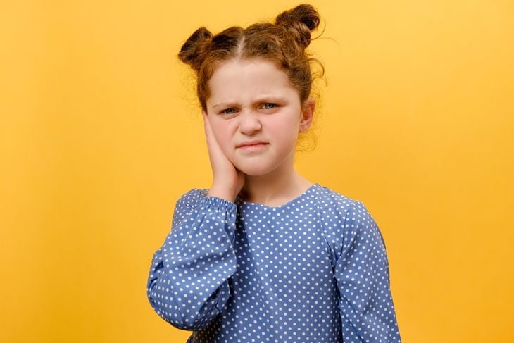 Portrait of unhappy preteen girl child suffering from ear pain