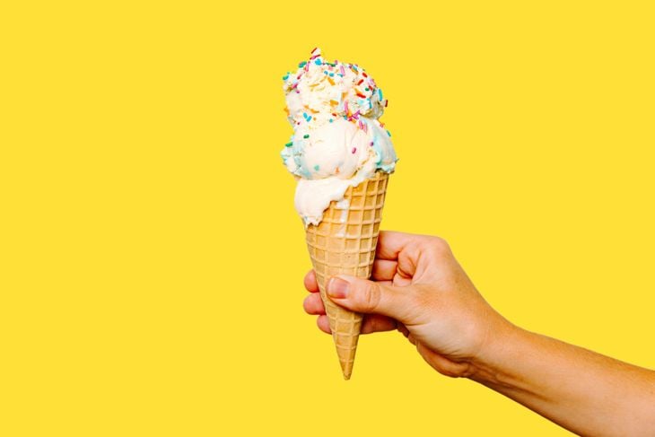 A hand holding an ice cream cone with sprinkles photo