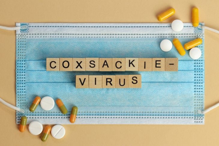 Coxsackievirus. The words are laid out with wooden cubes on a surgical face mask