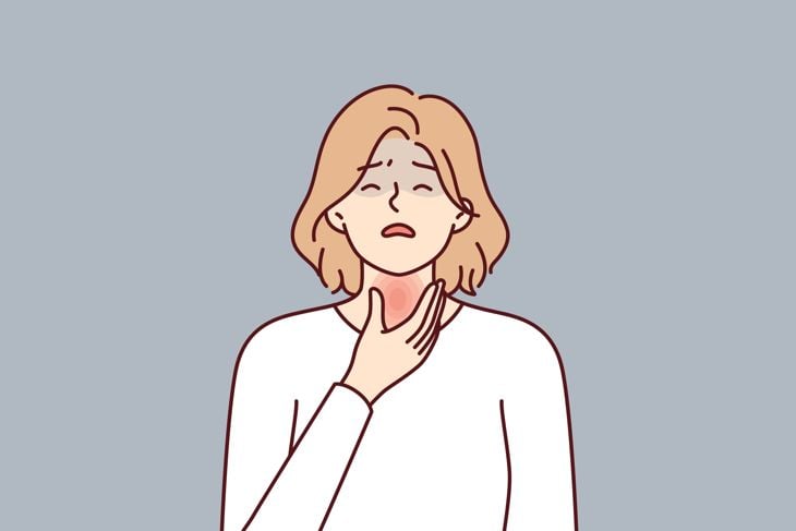 Woman is experiencing thyroid pain associated with hypothyroidism or cancer of endocrine system and puts hand on red neck