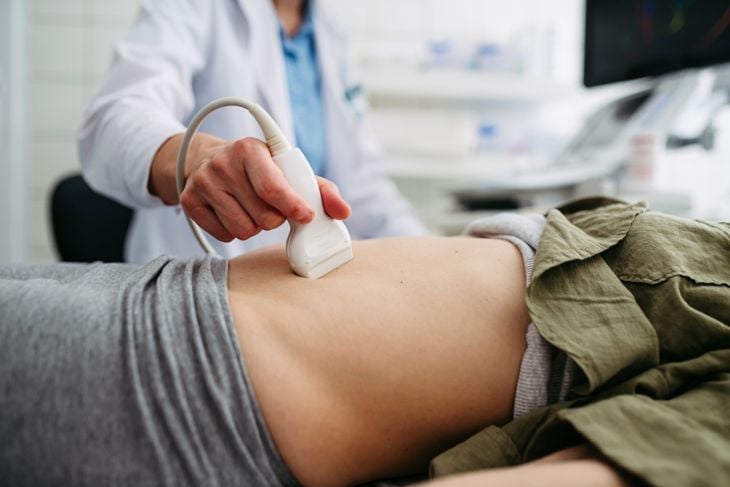 Female patient undergoing abdominal ultrasound screening.