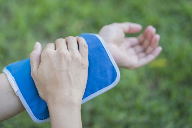 woman putting an ice pack on her arm pain