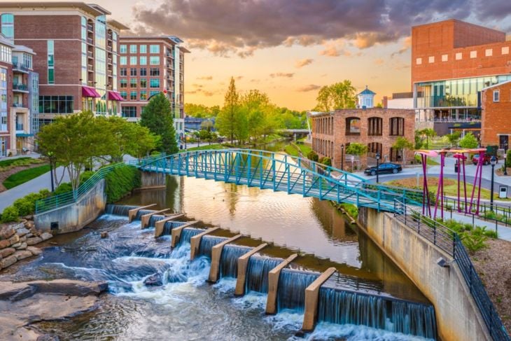 Greenville, South Carolina, USA downtown cityscape on the Reedy River at dusk.