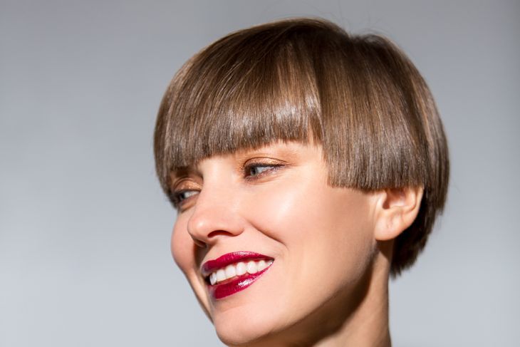 Smiling beautiful woman with brown short hair. Haircut. Hairstyle. Fringe. Professional makeup and tanned skin