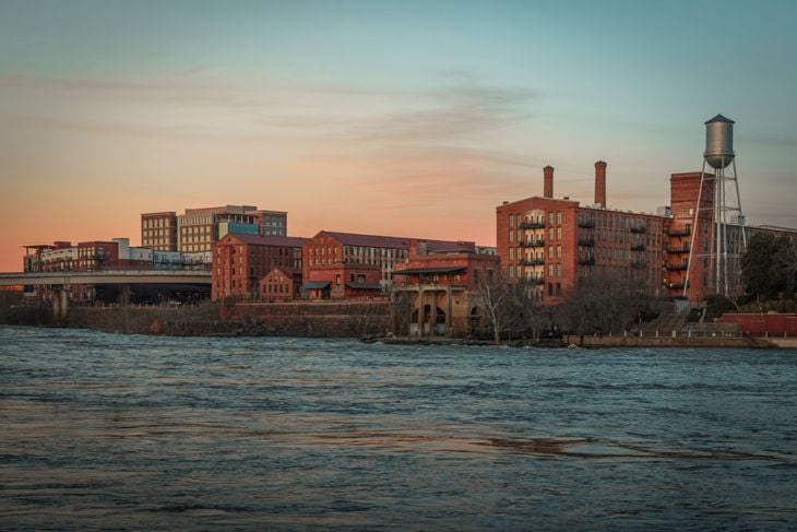 A view of the Columbus Georgia skyline at dusk from the edge of the Chattahoochee River standing in Phenix City Alabama.