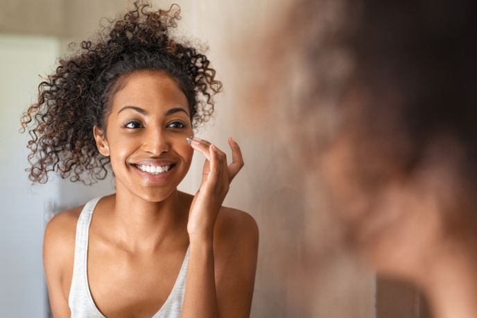 smiling woman applying face cream