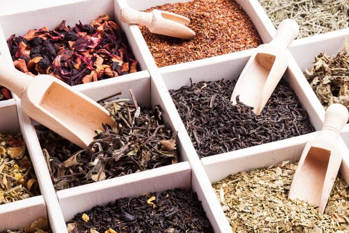 box of various loose teas with scoops