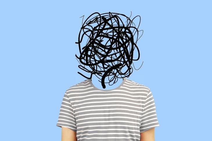 A person in a gray striped shirt stands against a blue background with their face replaced by a chaotic black scribble, visually representing disorientation and confusion linked to advanced Naegleria fowleri infection. 