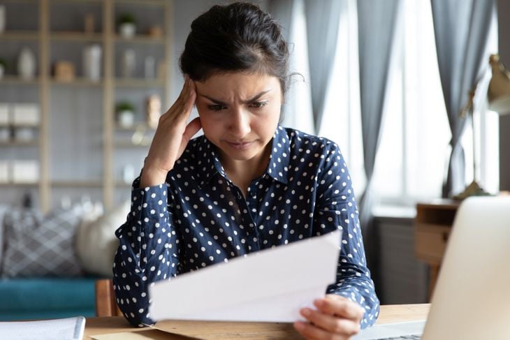 A woman reading a document has trouble focusing on the page, a symptom of early macular degeneration.