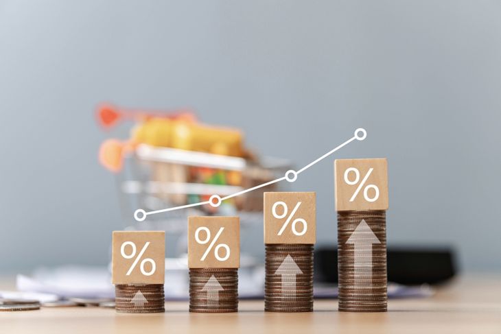 Stacks of coins topped with percentage symbol blocks increase in height from left to right, overlaid with an upward trend line—signaling rising loan costs and the importance of scrutinizing lender terms. 