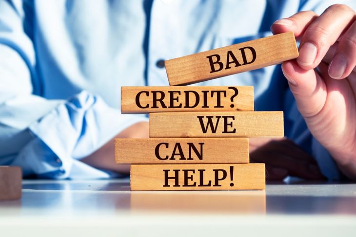 Wooden blocks with words 'Bad Credit Question We Can Help'.