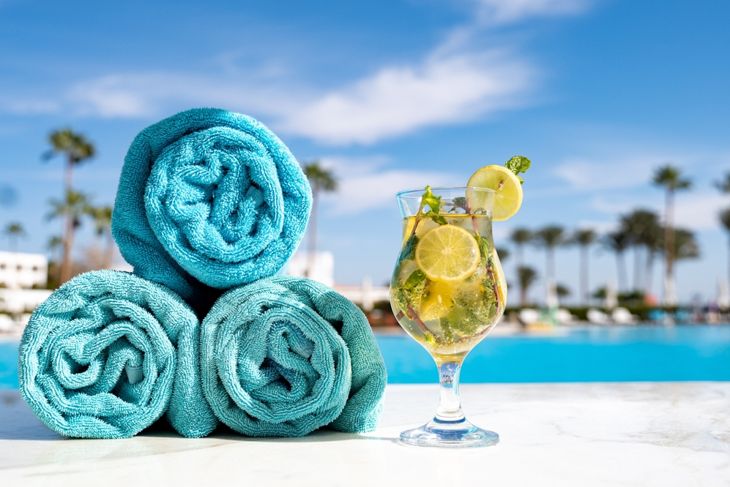 Blue towels with mohito cocktail on marble table in the hotel, all inclusive concept