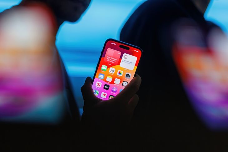 Man holding new iPhone 15 Pro titanium smartphone