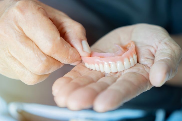 Close-up in the hand of a pensioner removable dentures