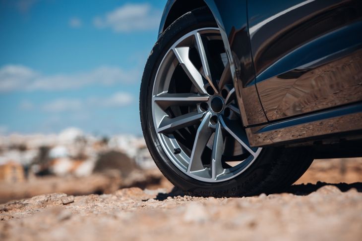 Close-up view of wheel of sports car at the gravel road