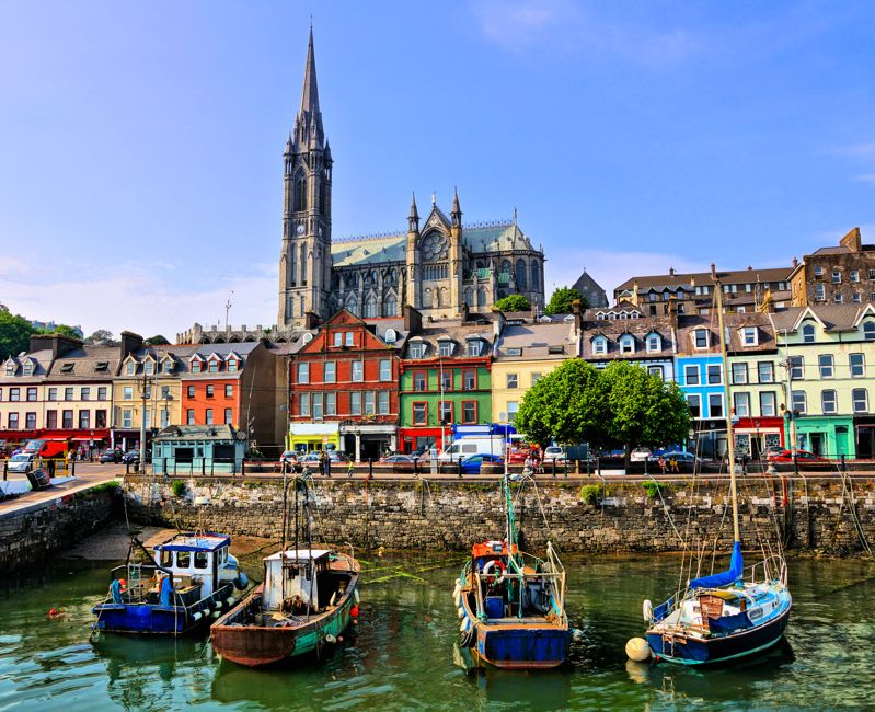 Colorful buildings, old boats and cathedral, Cobh harbor, County Cork, Ireland
