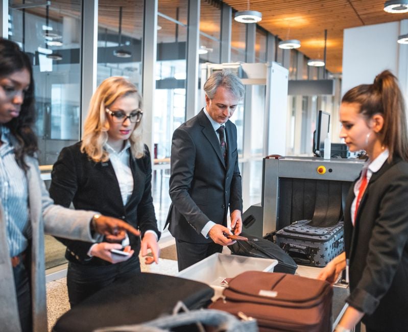 Passengers standing by security scanner at airport