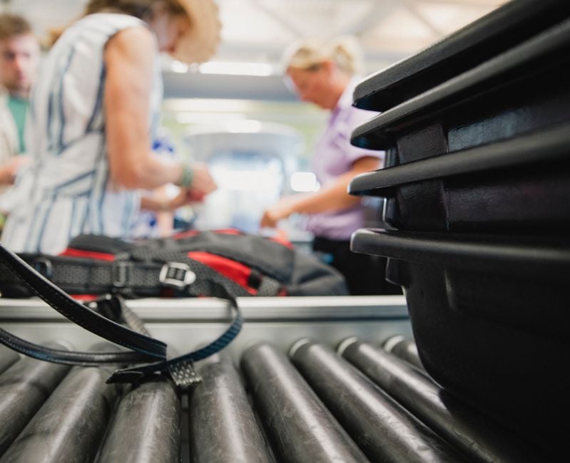 Close up shot of luggage being inspected by security at the airport.