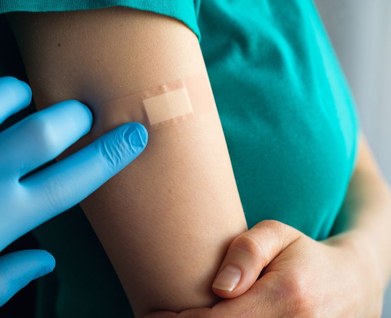 person with bandage after getting vaccine shot