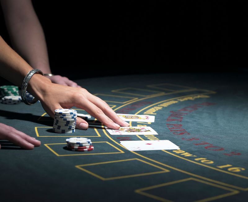 Two women playing Blackjack at gaming table, close-up