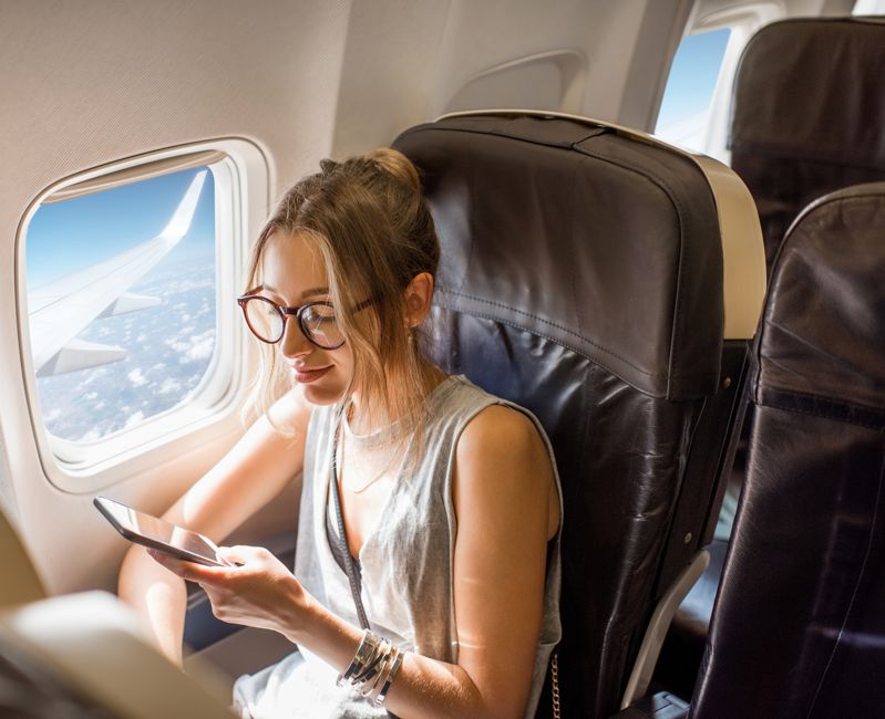 woman checking phone during flight