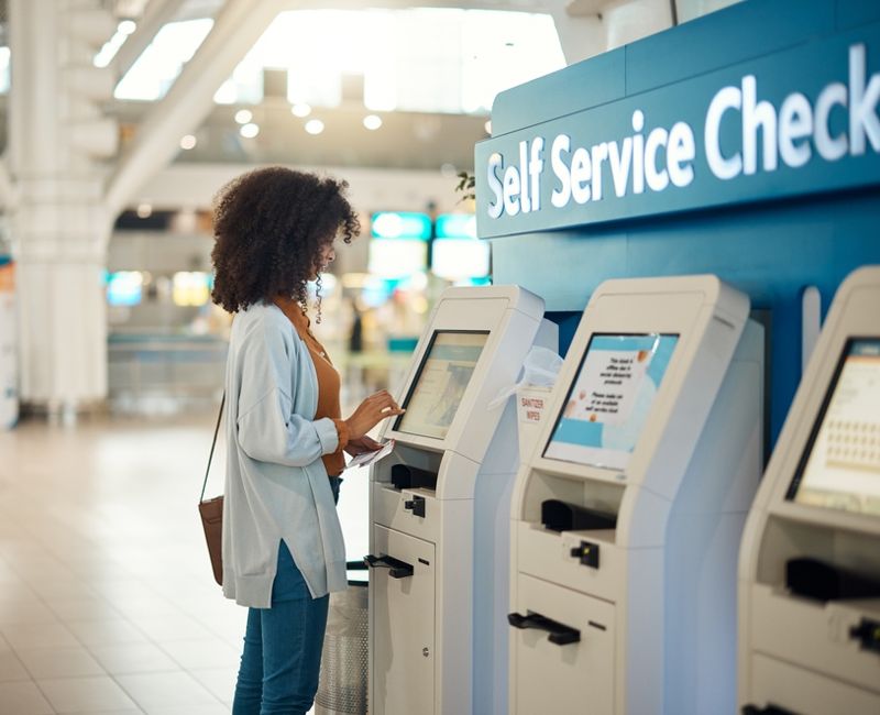 Black woman, airport and self service kiosk for check in