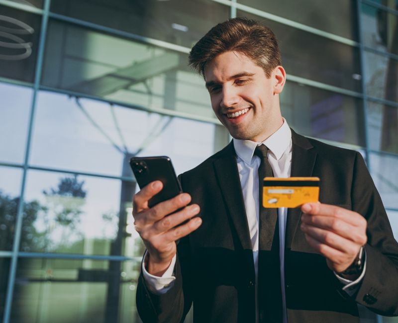 Bottom view traveler businessman man wear black suit stand outside at international airport terminal use mobile