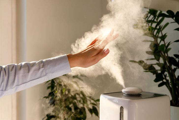 woman with hand over humidifier