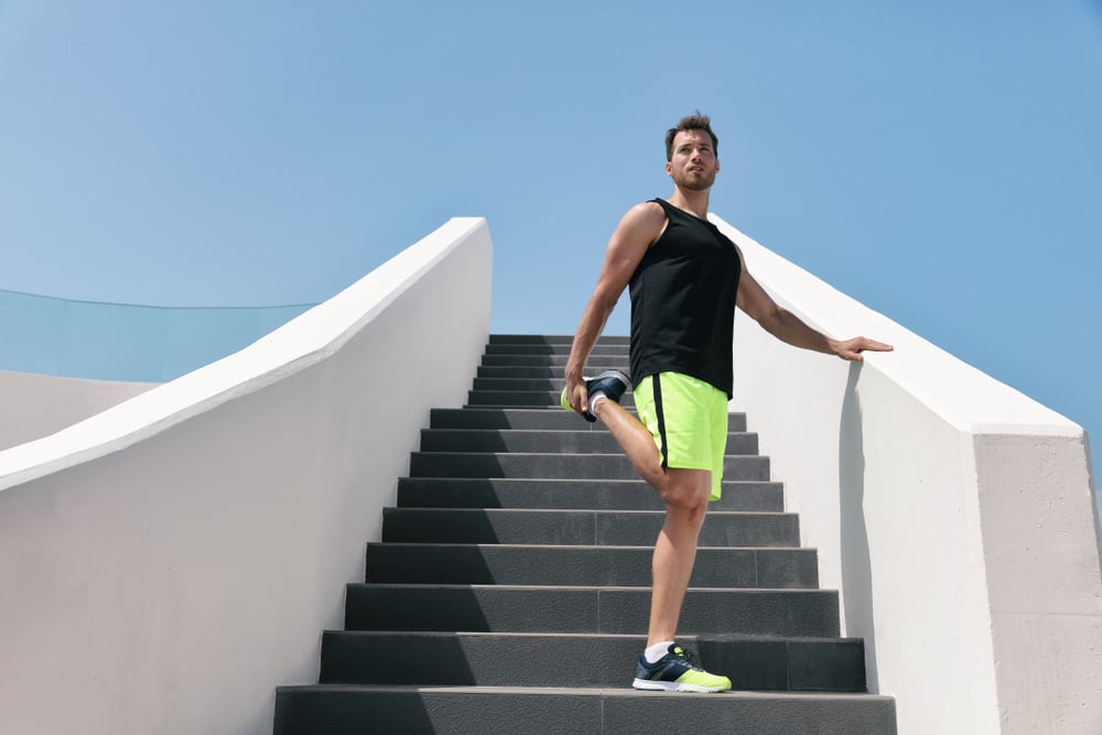 man on stairs doing quad stretch with bent knee